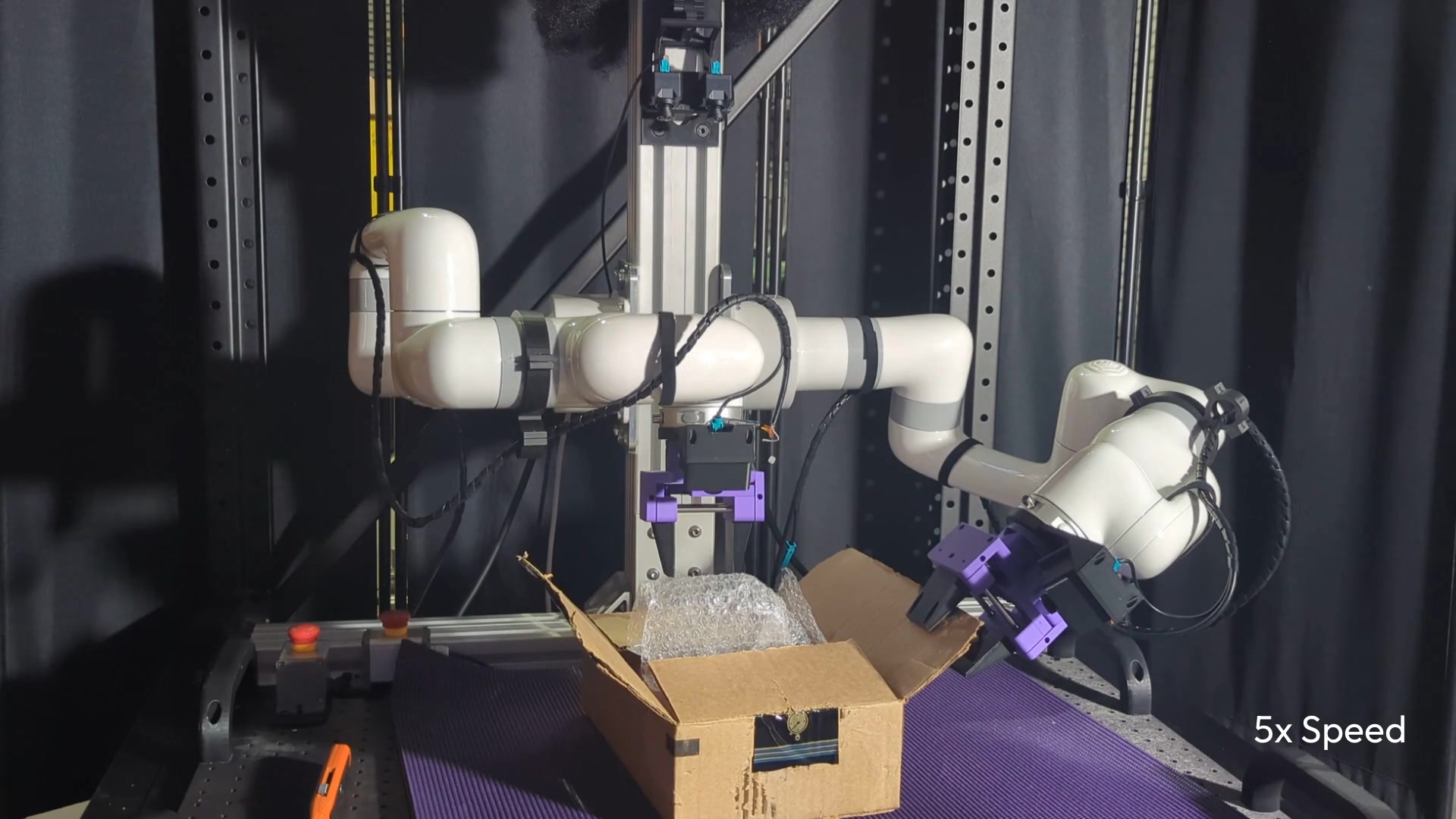 Bimanual robot arms reaching into a cardboard box to remove bubble wrap